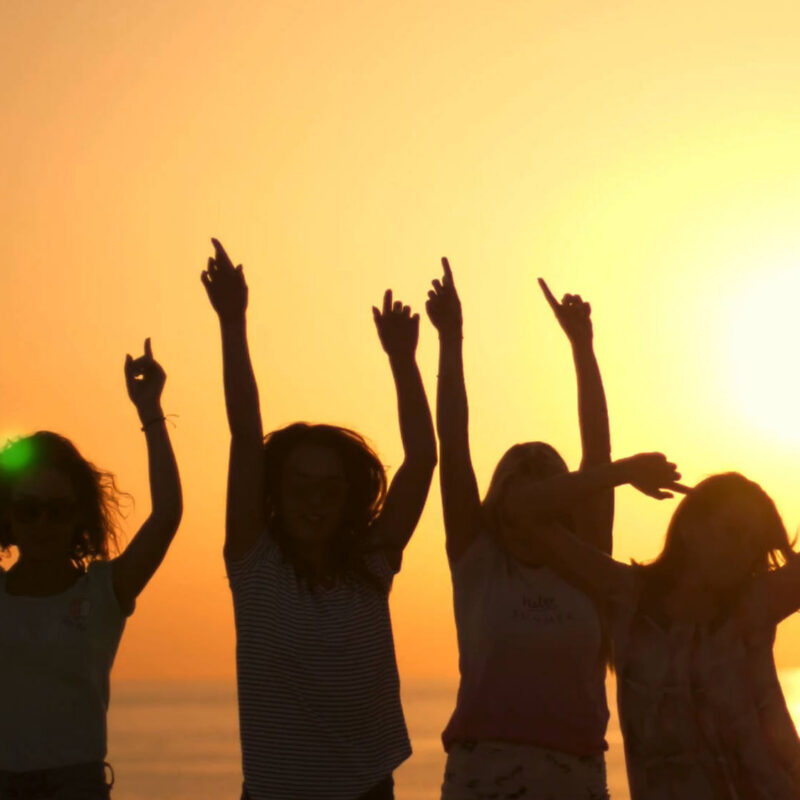 Young people dancing at the beach while the sun sets in the background. From the Mossbeard song - Only so many summers.
