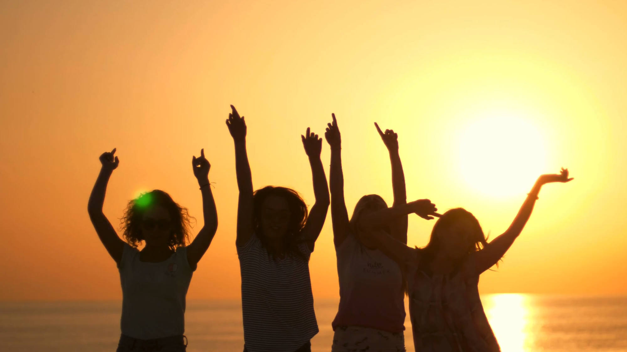 Young people dancing at the beach while the sun sets in the background. From the Mossbeard song - Only so many summers.