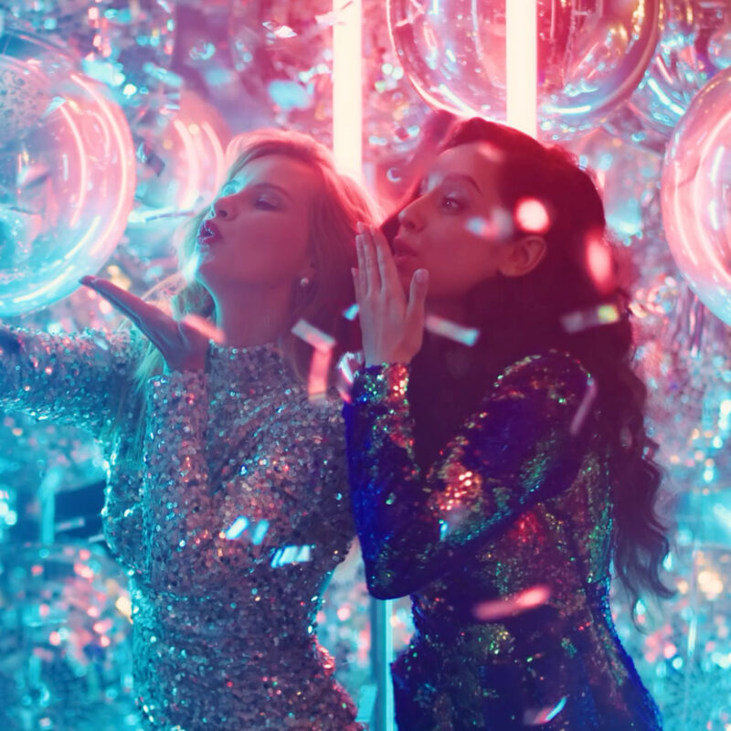 Two young woman at a party taking selfies and recording a live view for social media. From the Mossbeard song - The unseen