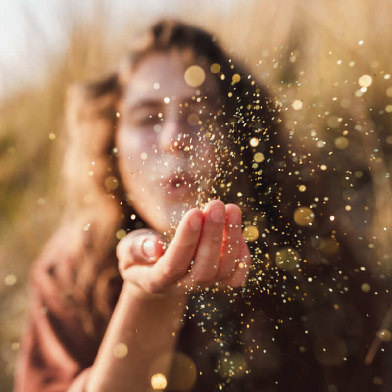 Mossbeard song - The more you got - A beautiful shot of a woman blowing glitter from her hand.