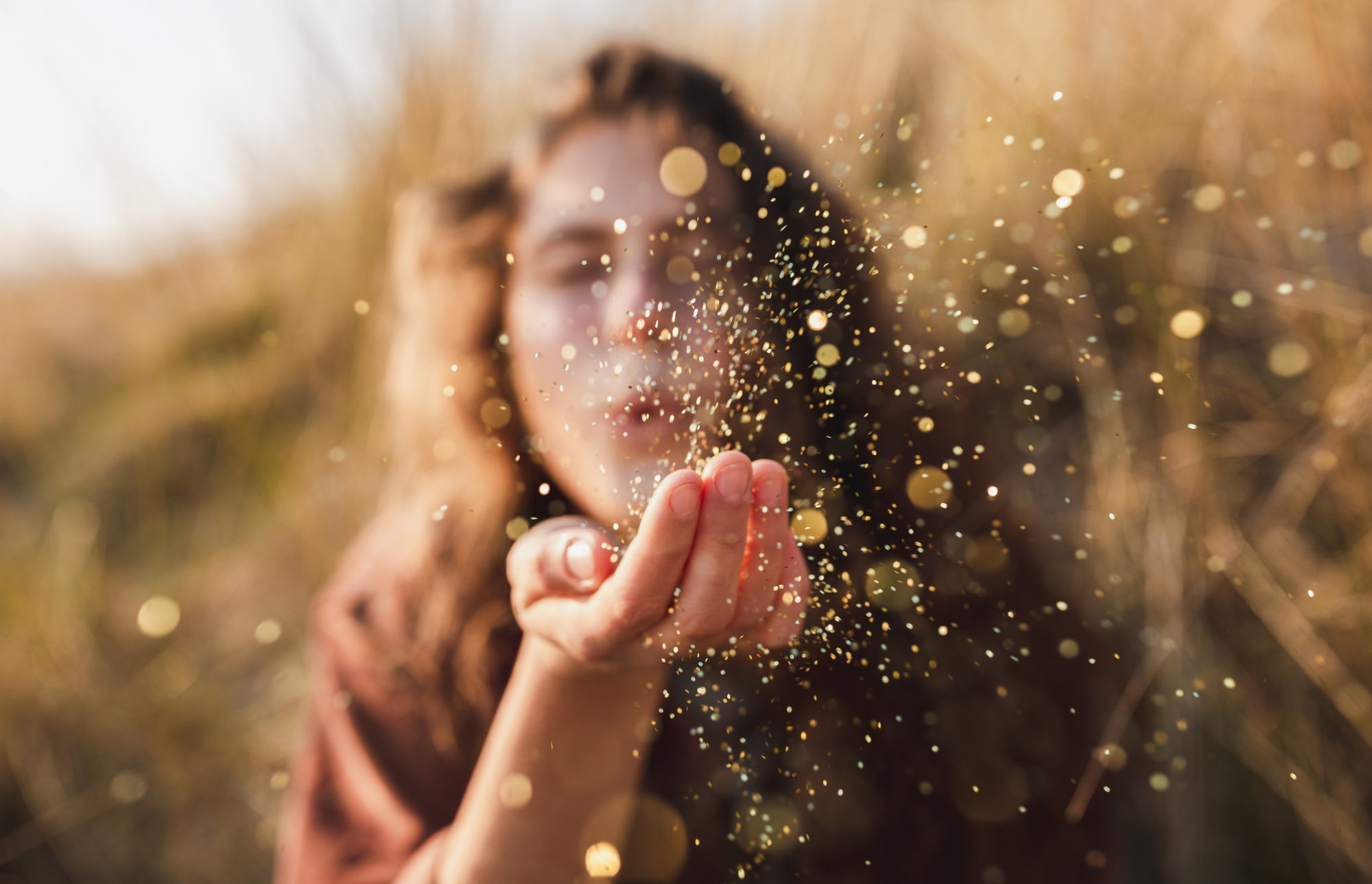 Mossbeard song - The more you got - A beautiful shot of a woman blowing glitter from her hand.